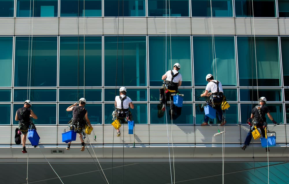 Team Of Climbing Workers Cleaning an Office Building