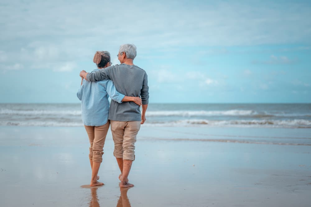 senior couple walking on the beach